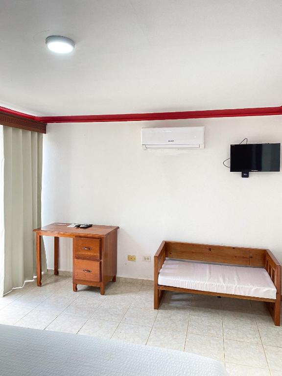 Camera con letto, scrivania e TV. di LUTIX HOTELS a El Limón