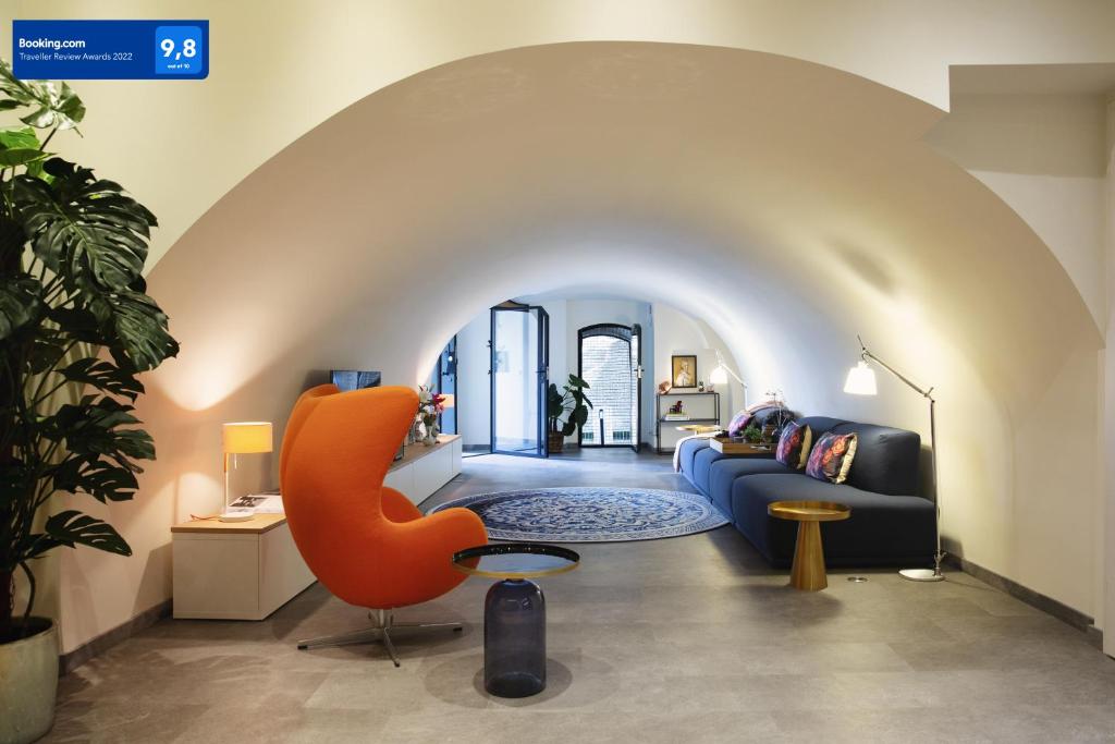 uma sala de estar com um sofá azul e uma cadeira laranja em LOFT 188 Luxury Apartment Hotel em Utrecht