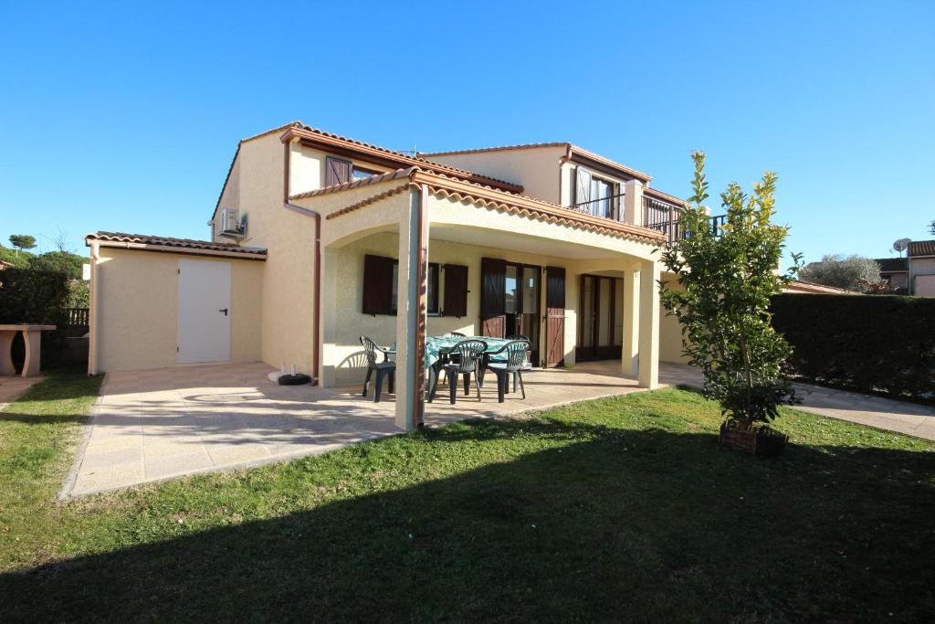 Cette maison dispose d'une terrasse et d'une table dans la cour. dans l'établissement Spacieuse Maison d'angle dans domaine des TAMARIS 5 pièces 6 á 7 couchages WIFI- Accès payant pour piscines-animation - PORTIRAGNES PLAGE LRTAMJ37, à Portiragnes