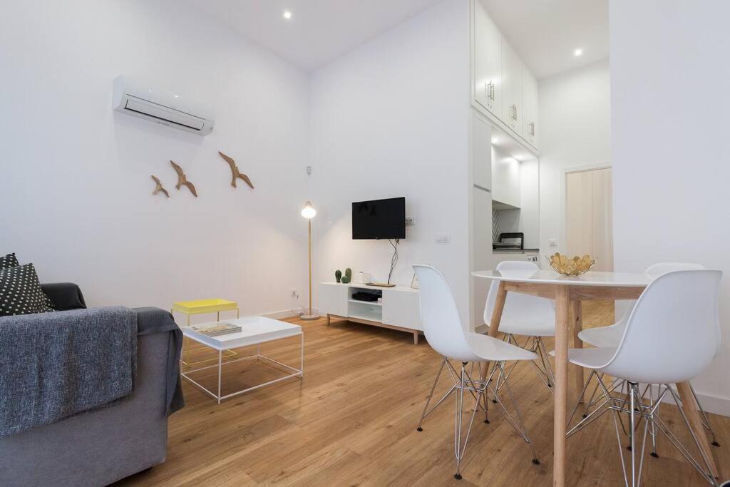 een woonkamer met een bank en een tafel en stoelen bij Apartamento Las 3 Gaviotas in Cádiz