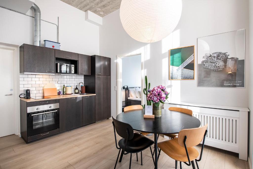 uma cozinha e sala de jantar com mesa e cadeiras em The Beach apartments by Daniel&Jacob's em Copenhaga