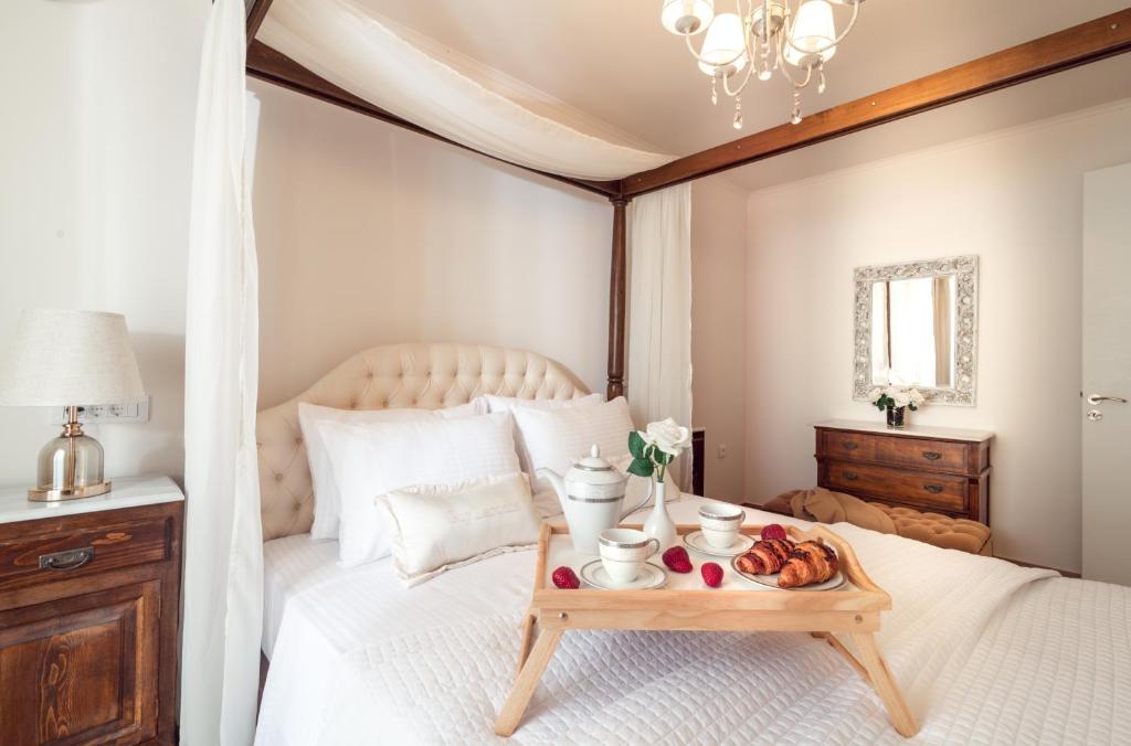 a bedroom with a bed with a tray of food on it at Maison Downtown Luxury Apartments! in Zakynthos