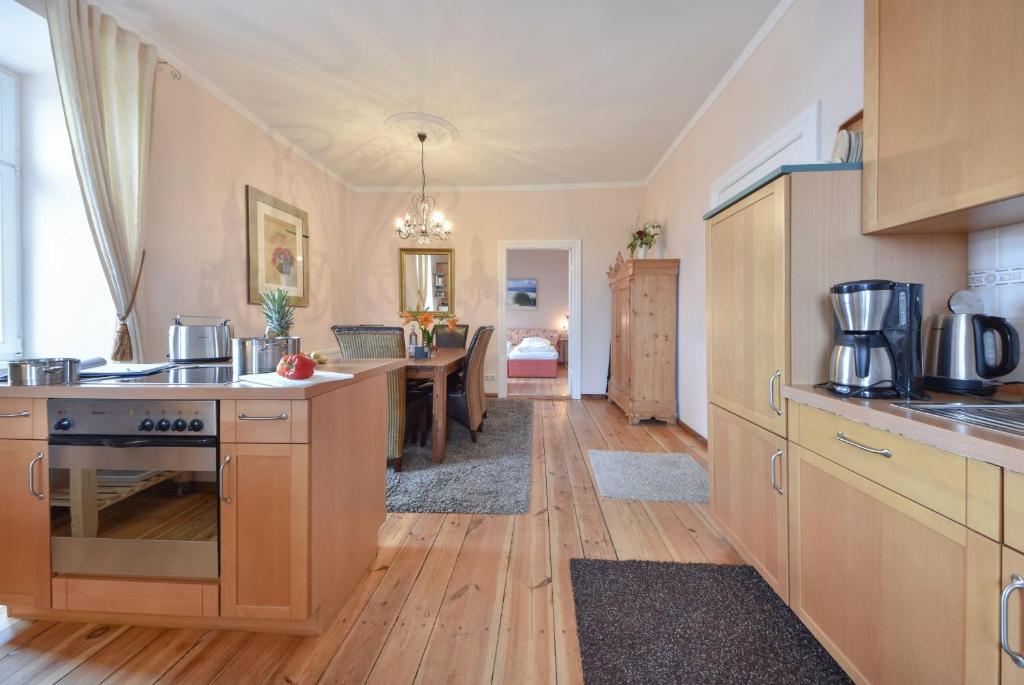 a kitchen with wooden cabinets and a dining room at Villa Magdalena 05 in Ahlbeck