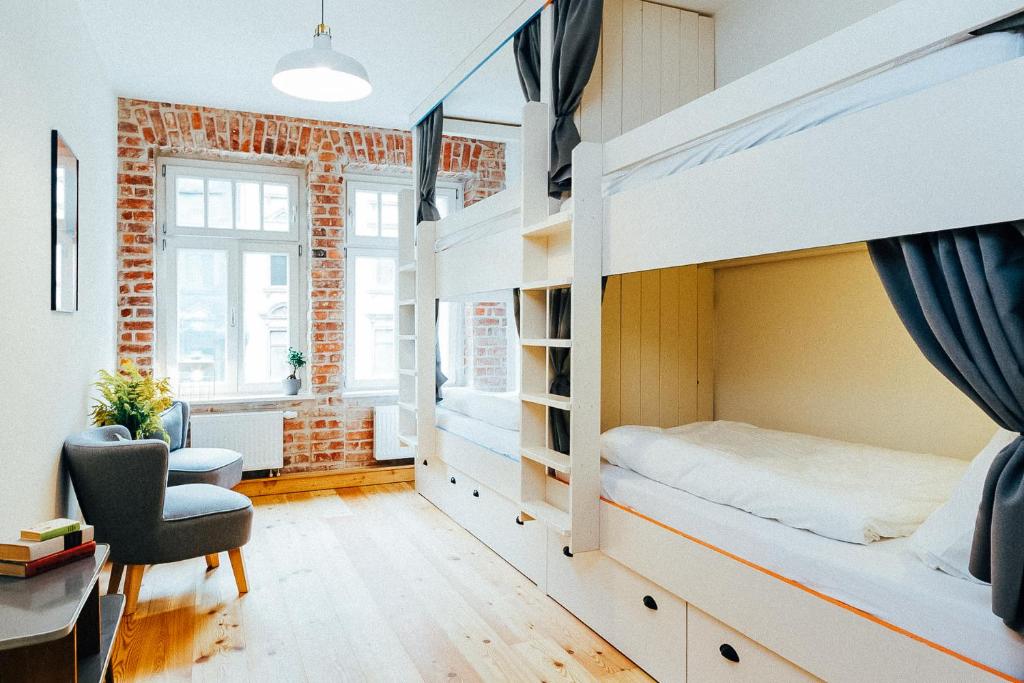 a bedroom with a bunk bed with a desk and a chair at Hostel Multitude in Leipzig