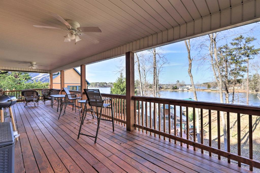 a screened porch with chairs and tables and a view of the water at Lakefront Sparta Cottage with Decks and Boat Dock in Sparta