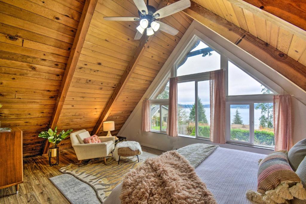 Habitación en el ático con ventilador de techo y ventanas grandes. en Coastal Cabin with Puget Sound and Rainier Views!, en Allyn