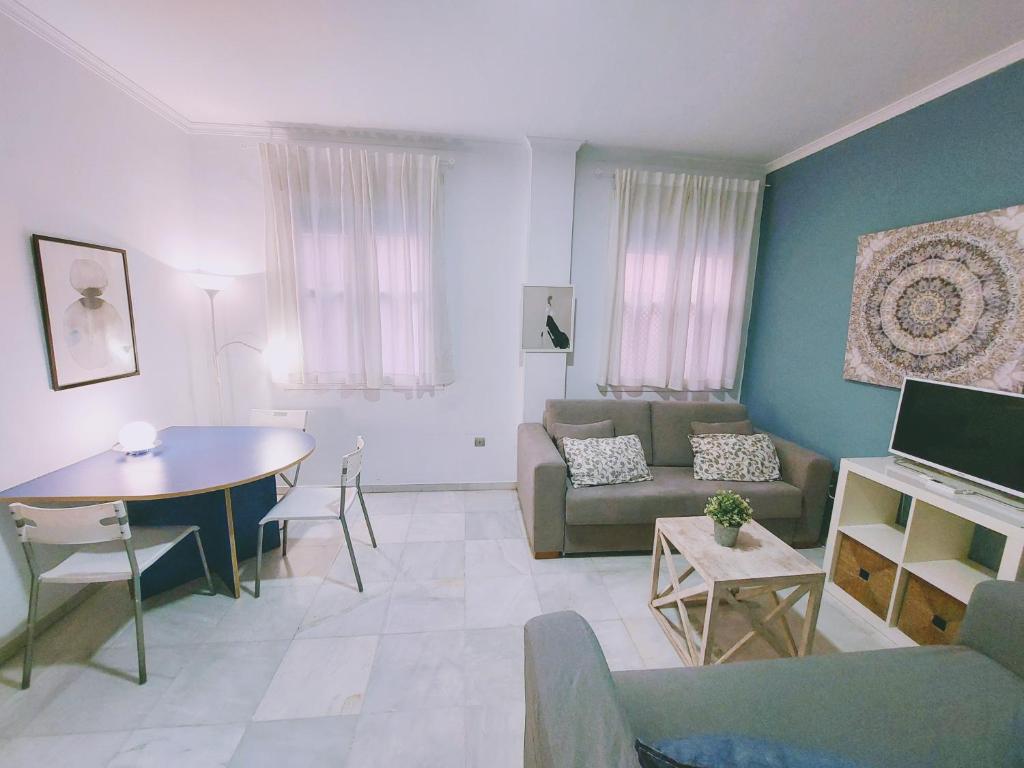 sala de estar con sofá y mesa en Alojamientos Morgado, en Sevilla