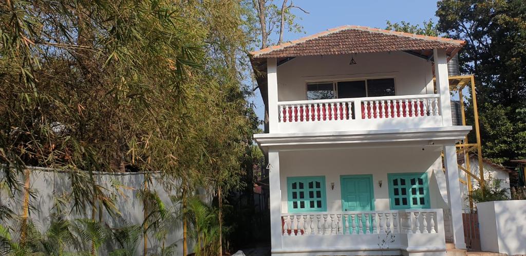 a white house with a balcony and a fence at Casa Aluizio in Assagao