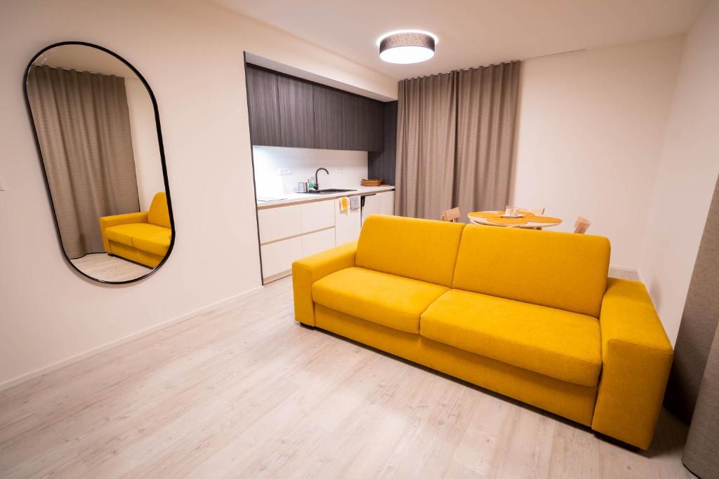 a yellow couch in a living room with a mirror at Hillside Y34 in Dolný Kubín