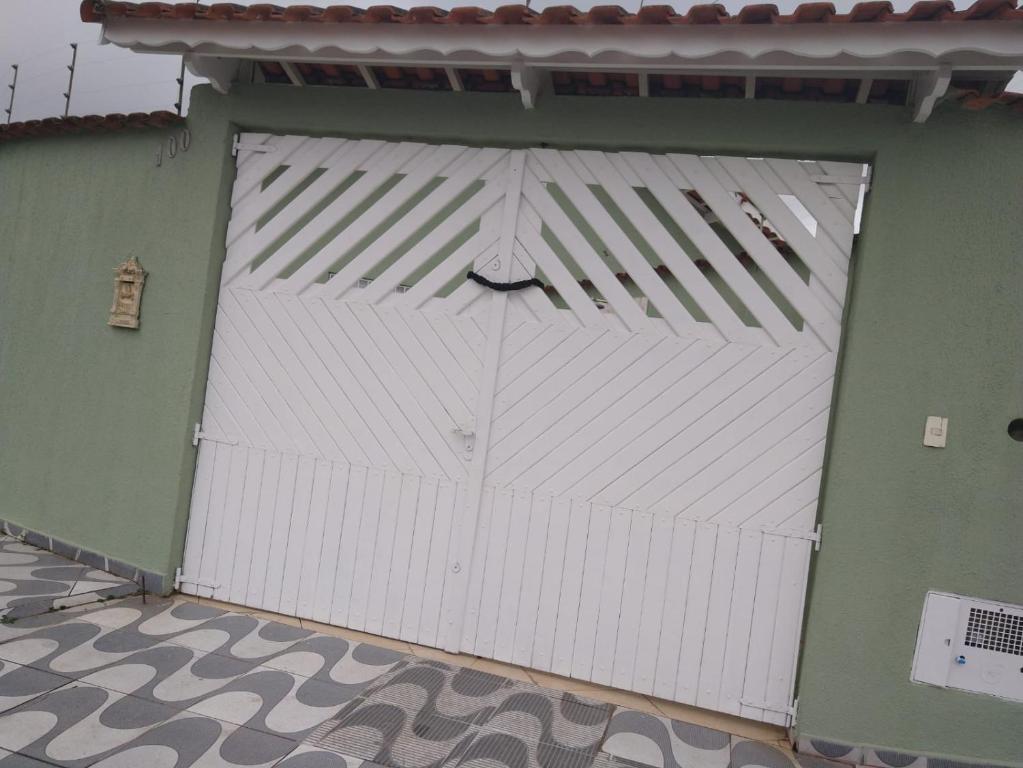 a white garage door with a face on it at Linda casa novinha in Mongaguá
