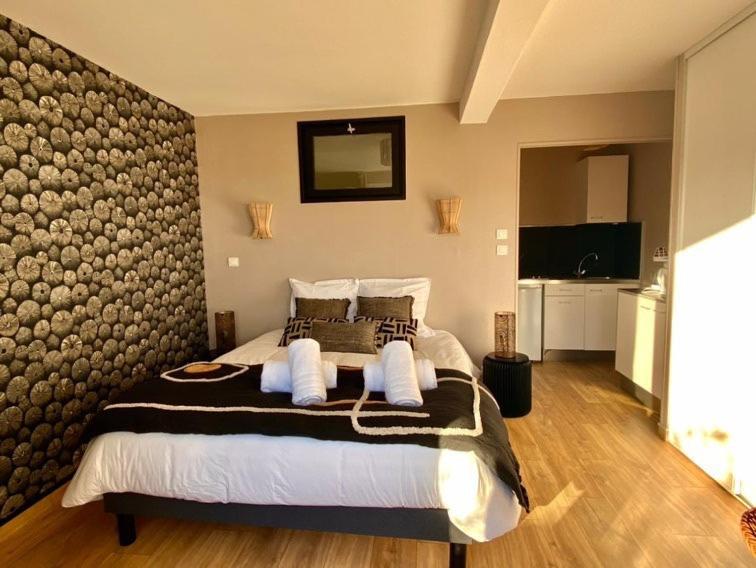 a bedroom with a large bed with a wall at Les Villas de la Plage in Névez