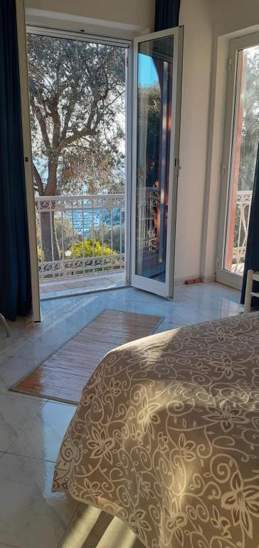 una camera con un letto e una grande porta scorrevole in vetro di Casa Melograno a Finale Ligure