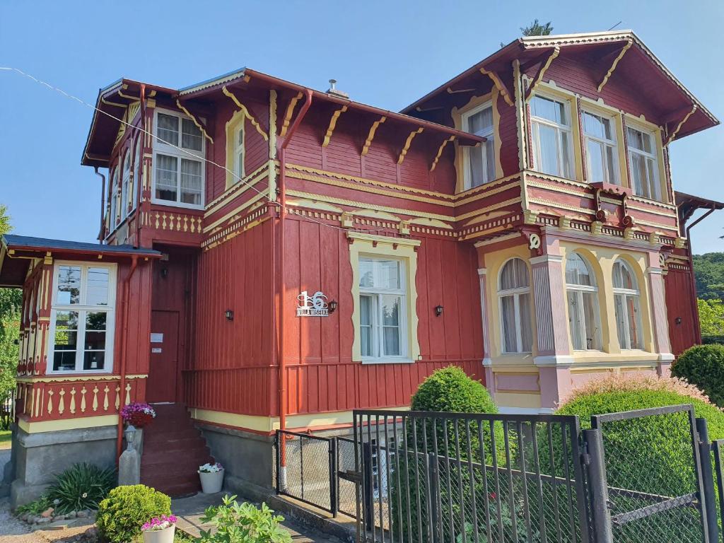 a red house with a fence in front of it at Willa Wiselka in Wisełka