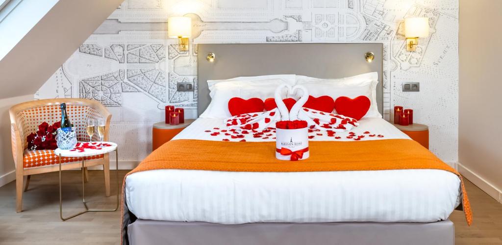 a bedroom with a bed with red hearts on it at Hotel Montbriand Antony - Ancien Alixia in Antony