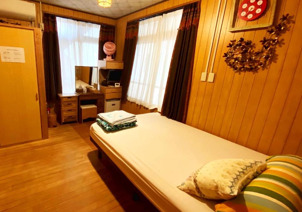 a bedroom with a bed and a tv and windows at Guest house Icyaribacyoude - Vacation STAY 09894v in Naha