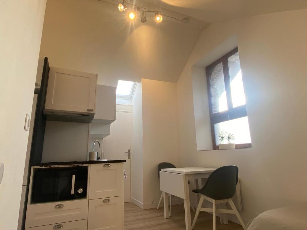a small kitchen with a desk and a window at Studio dans les écuries du chateau in Bonnelles
