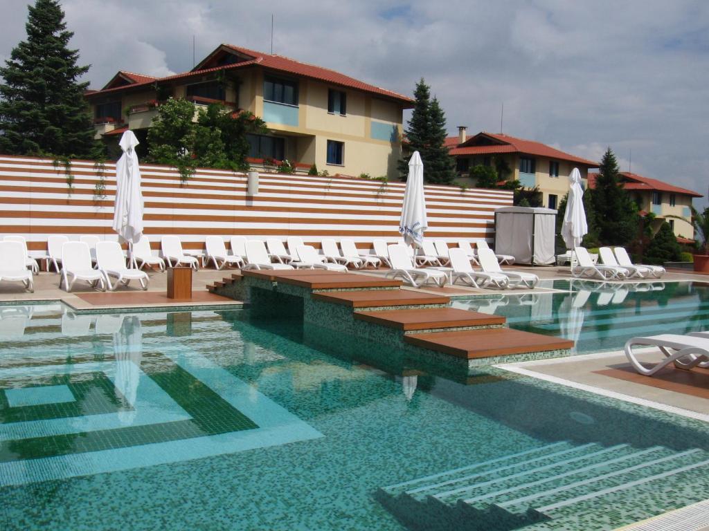 a swimming pool with lounge chairs and a building at Tsarsko Selo Spa Hotel in Sofia