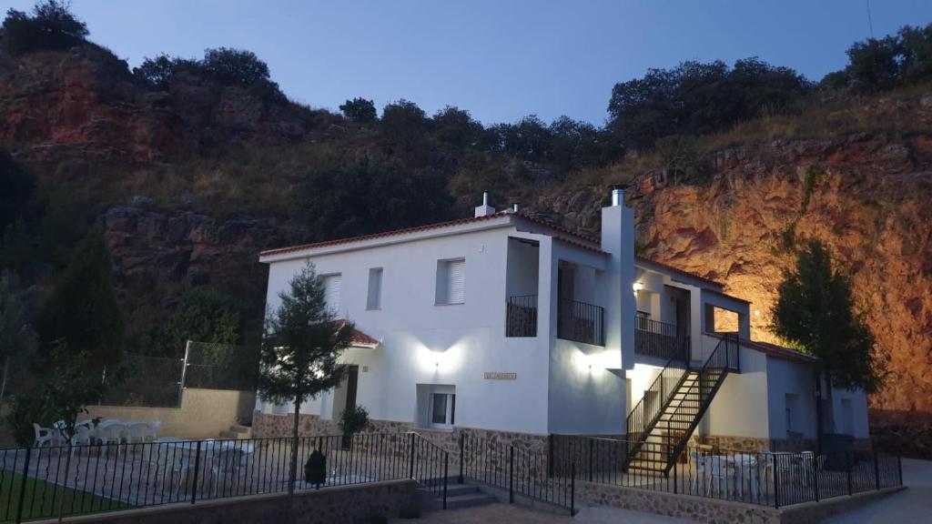una casa blanca con escaleras frente a una montaña en Casas rurales La Carrasca en Ossa de Montiel