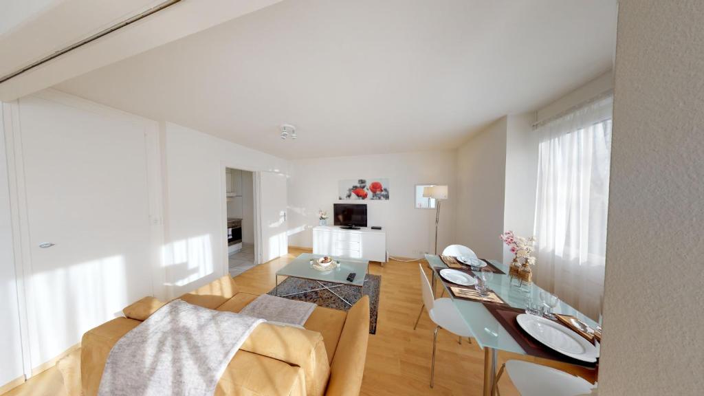 ein Wohnzimmer mit einem Tisch und einem Esszimmer in der Unterkunft Unique Serviced Living @ St. Johann Davidsrain in Basel
