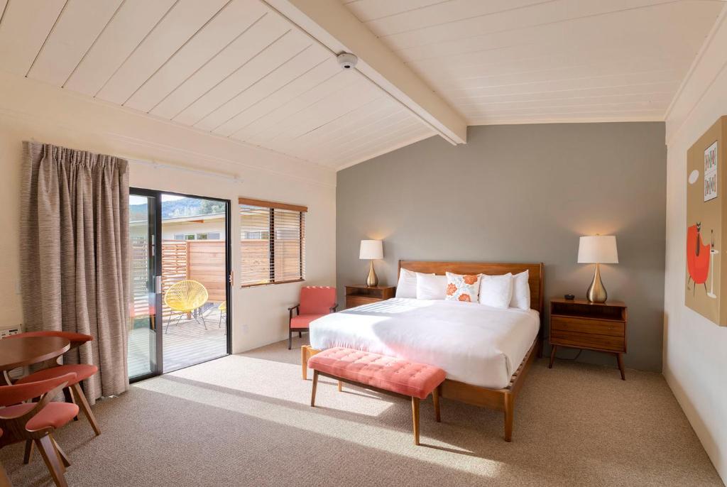 a bedroom with a bed and a table and chairs at Contenta Inn in Carmel Valley