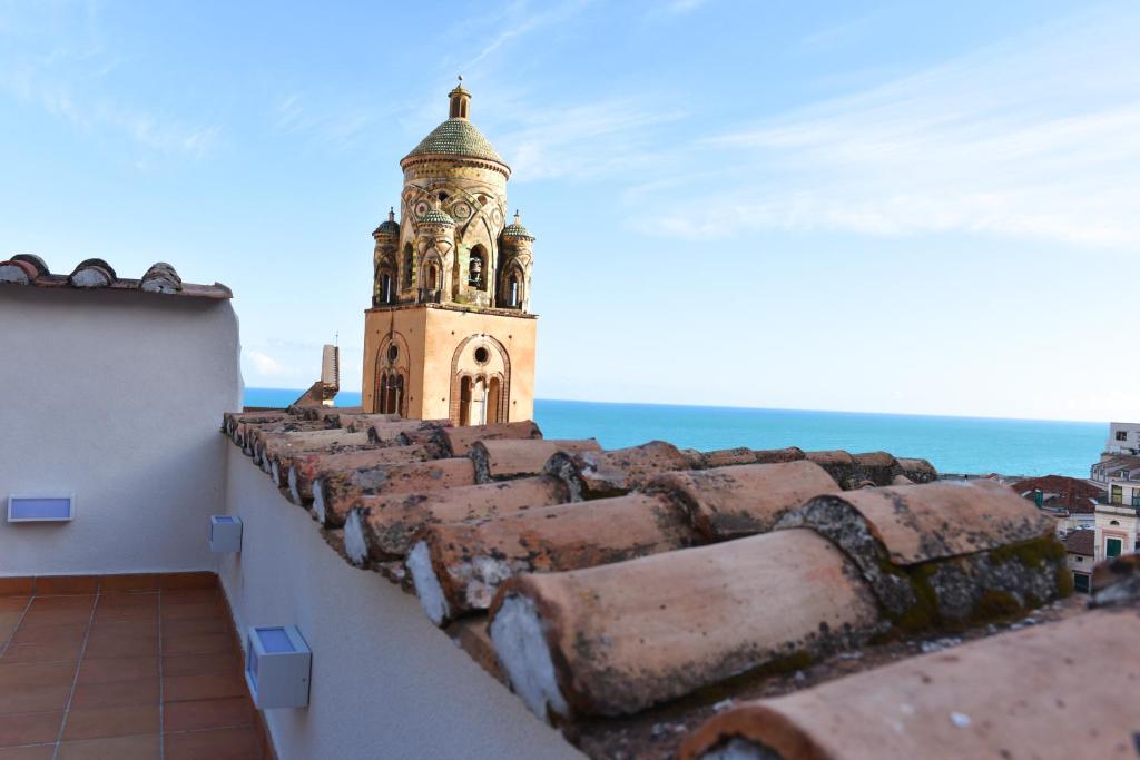 una torre de reloj sentada en la parte superior de un edificio en Appartamento - Antica Residenza Amalfitana, en Amalfi