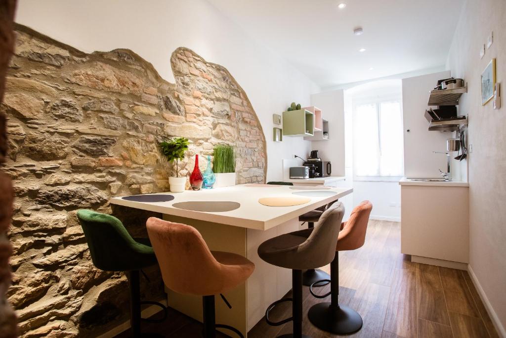 a kitchen with a stone wall and a kitchen island with chairs at Design Suite Cinque Terre La Spezia in La Spezia