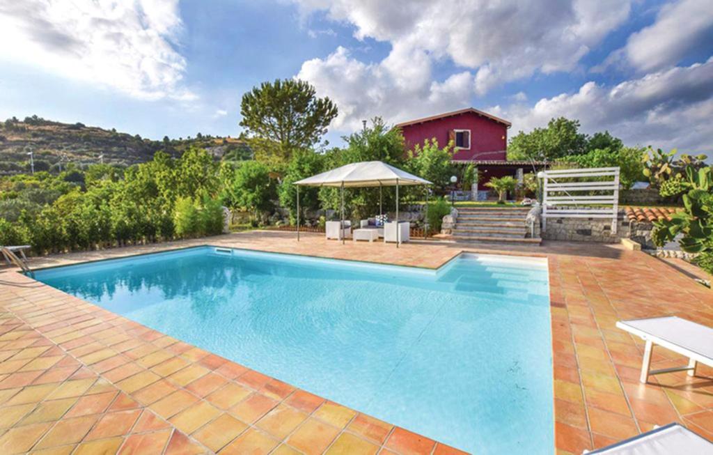 a swimming pool in a yard with a house at Ceretanum Holiday House in Giarratana