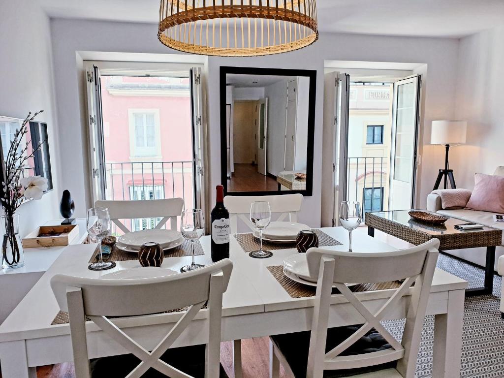 ein Esszimmer mit einem weißen Tisch und Stühlen in der Unterkunft Sherryflat C/Larga in Jerez de la Frontera