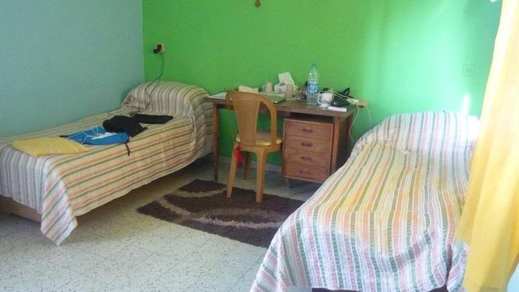a bedroom with two beds and a desk at B&B at Palestinian home / Beit Sahour in Bethlehem
