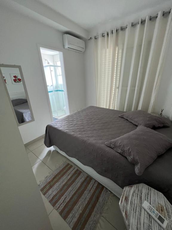 - une chambre avec un grand lit et un miroir dans l'établissement Boulevard Family Club/ Bertioga - SP, à Bertioga