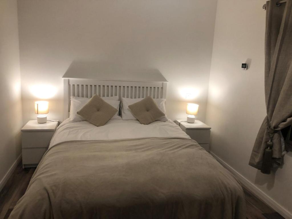 a bedroom with a large bed with two lamps at Kearney's Cottage B&B in Killenard