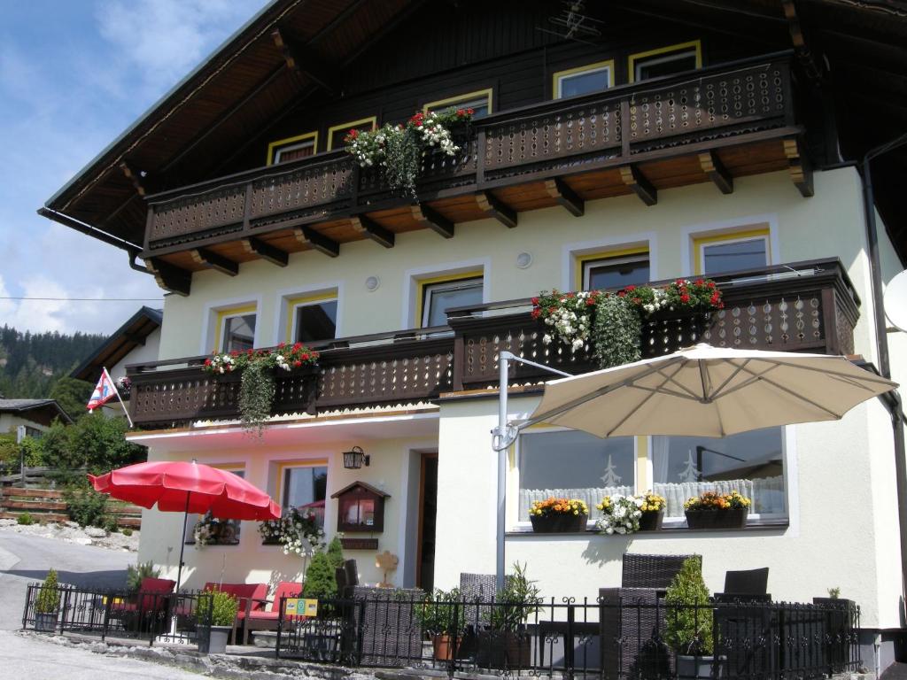 un edificio con una sombrilla delante de él en Pension Haus Maria, en Ramsau am Dachstein