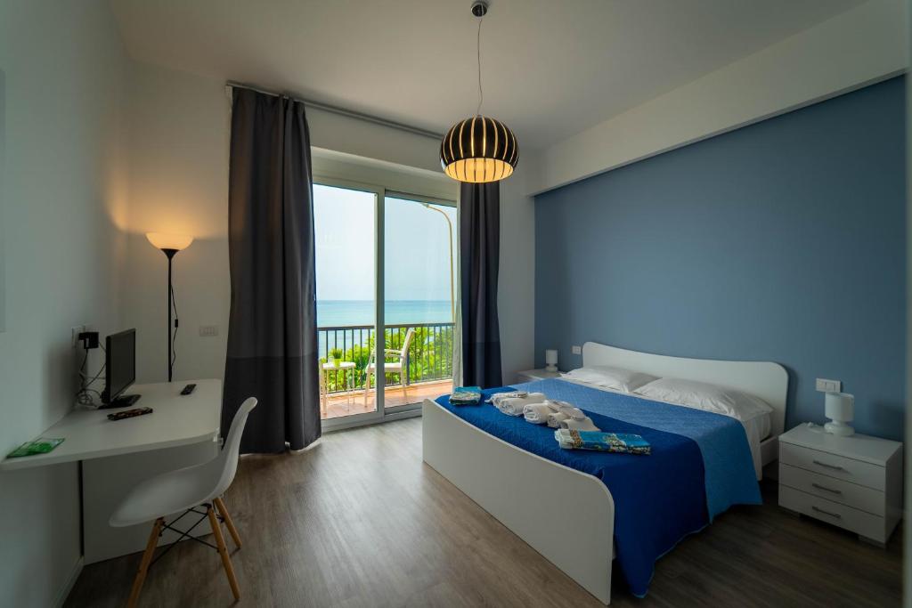 a bedroom with a bed and a desk and a window at Sicilian Charm in Marina di Ragusa