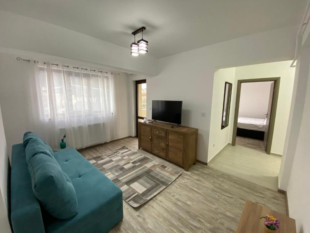 ein Wohnzimmer mit einem blauen Sofa und einem TV in der Unterkunft Renting Solutions Deluxe in Iaşi