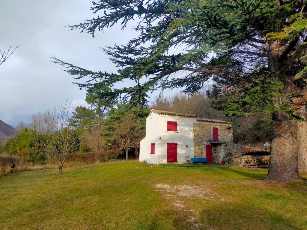 una casa vieja en un campo con un árbol en Gîte au pays des lavandes en Aurel