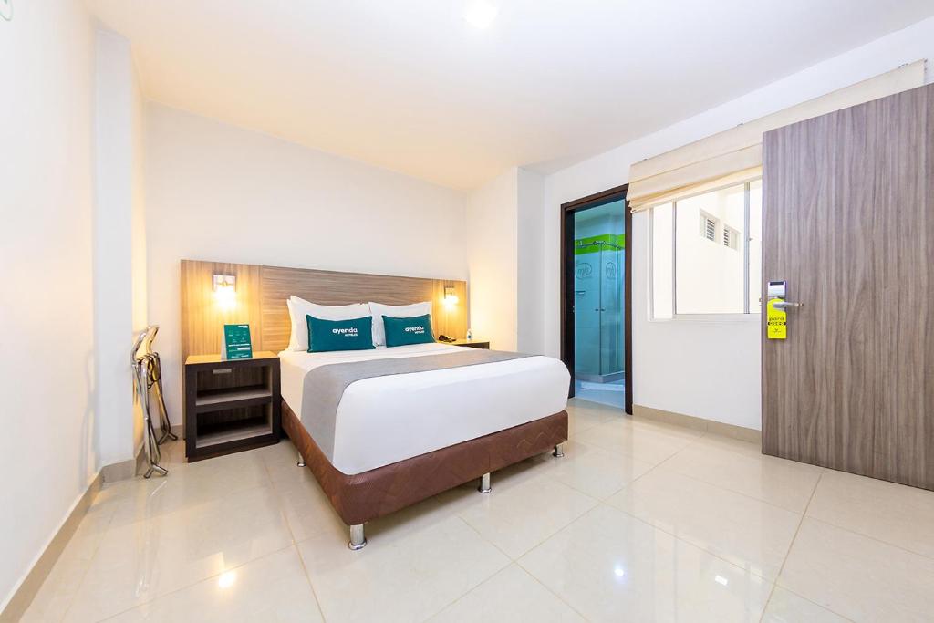 a large bedroom with a large bed and a door at Ayenda 1136 MH in Pereira