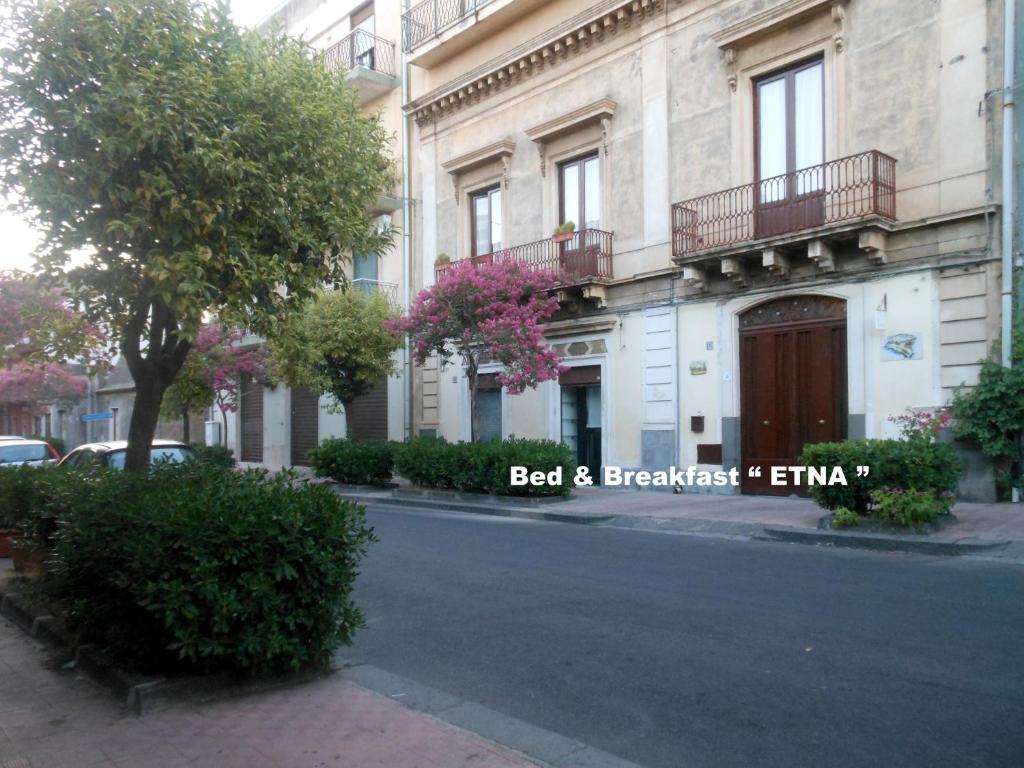 un bâtiment avec un panneau sur le côté d'une rue dans l'établissement Etna, à Belpasso