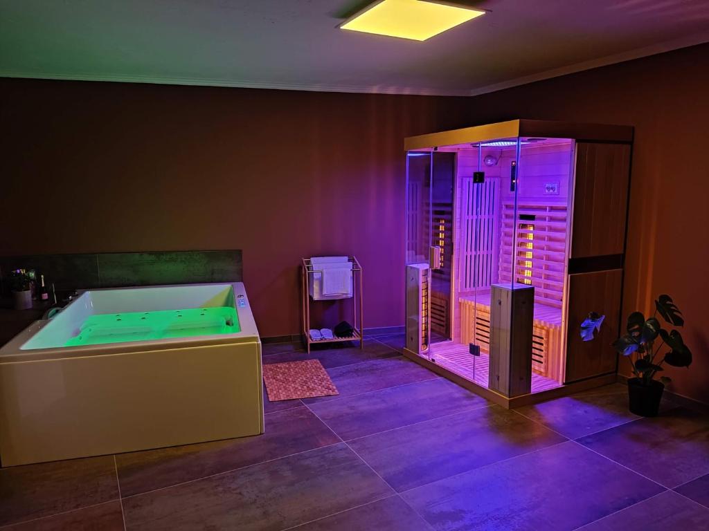 una camera con vasca e luci viola di La pépite de l'Eifel a Bullange/Büllingen