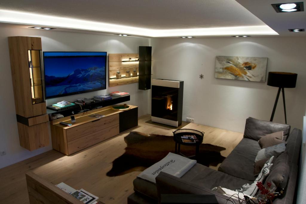 uma sala de estar com um sofá, uma televisão e uma lareira em Modernes & Erholsames Leben em Mötz