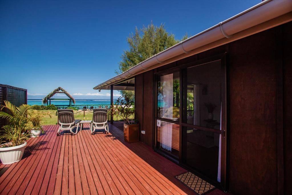 a deck with two chairs on it with a view of the ocean at Vai Villas in Avarua