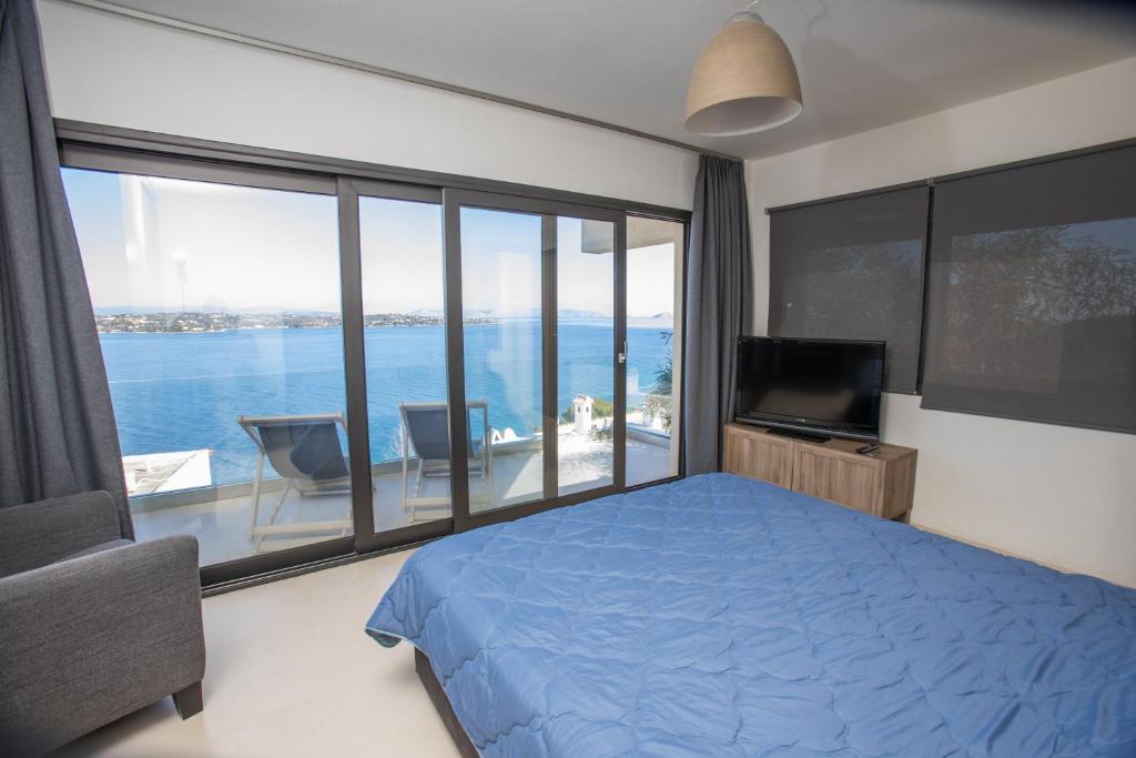 a bedroom with a blue bed and a large window at Raise Spetses Sea View Villa in Spetses