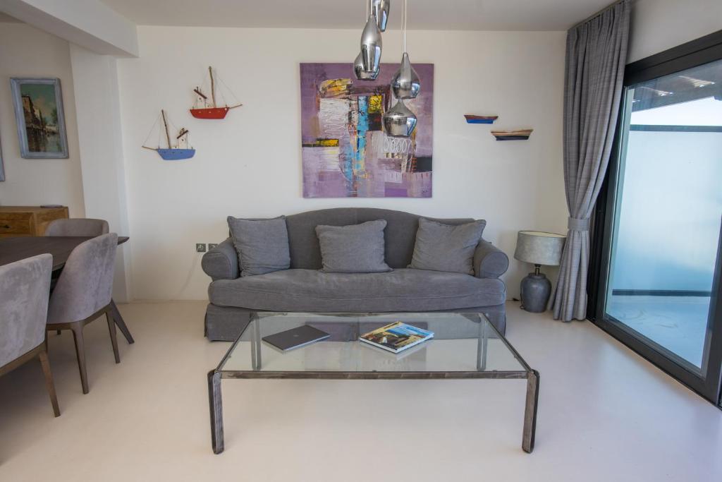 a living room with a couch and a glass table at Raise Spetses Sea View Villa in Spetses