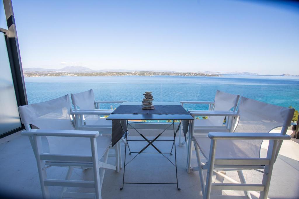 a table and chairs on a balcony with a view of the ocean at Raise Spetses Sea View Villa in Spetses