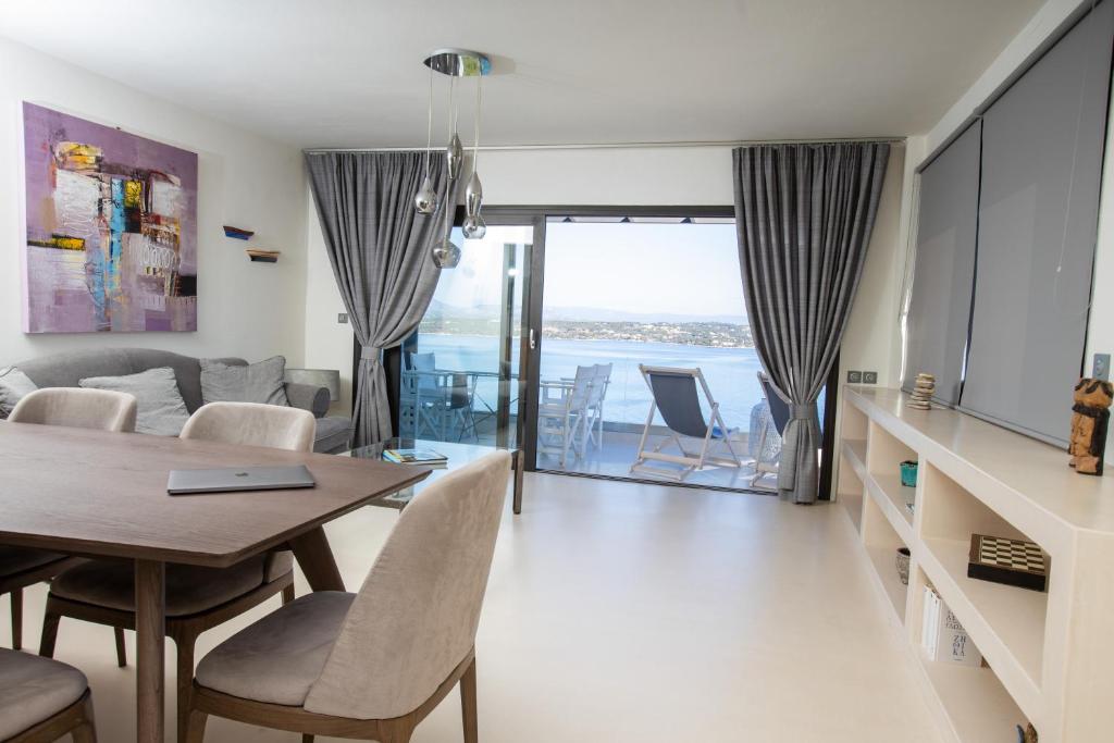 a dining room and living room with a table and chairs at Raise Spetses Sea View Villa in Spetses