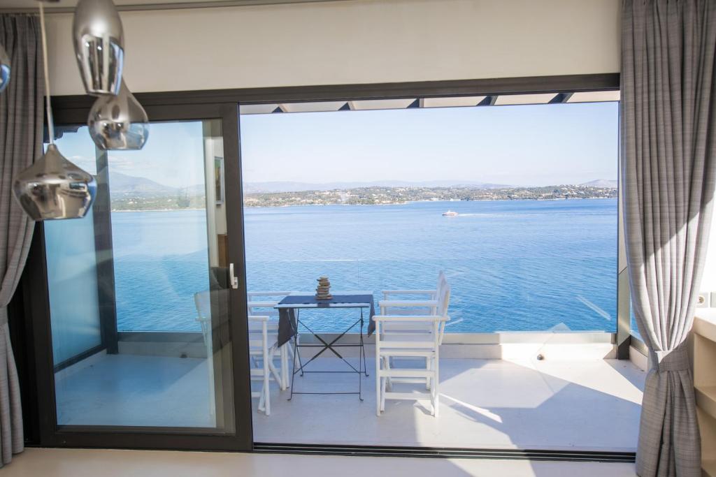 a dining room with a view of the water at Raise Spetses Sea View Villa in Spetses