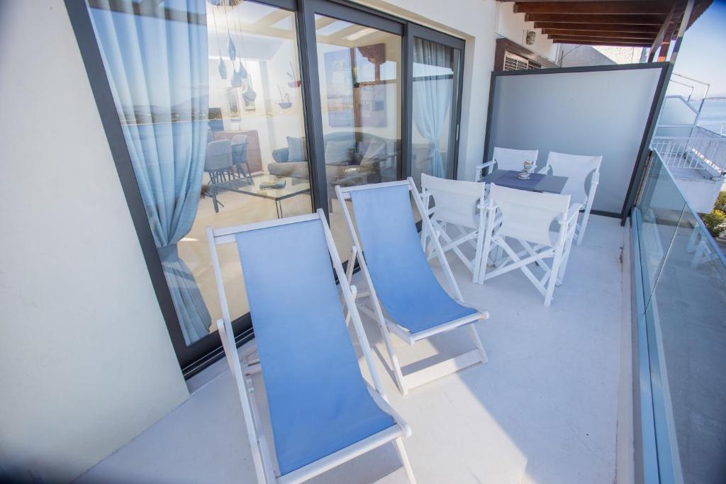 a balcony with a table and chairs on a balcony at Raise Spetses Sea View Villa in Spetses