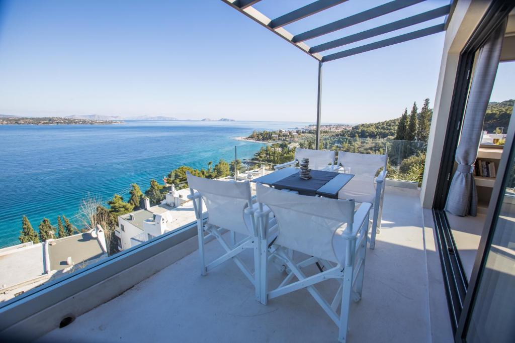 a balcony with a table and chairs overlooking the ocean at Raise Spetses Sea View Villa in Spetses
