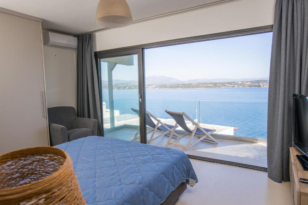 a bedroom with a bed and a view of the ocean at Raise Spetses Sea View Villa in Spetses