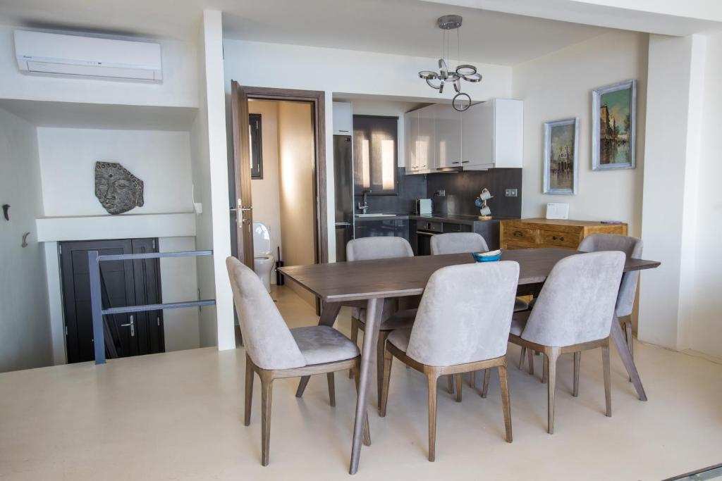 a kitchen and dining room with a wooden table and chairs at Raise Spetses Sea View Villa in Spetses