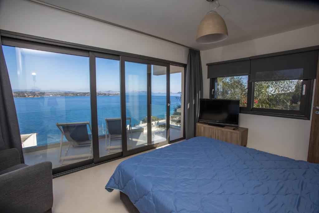a bedroom with a bed and a view of the water at Raise Spetses Sea View Villa in Spetses